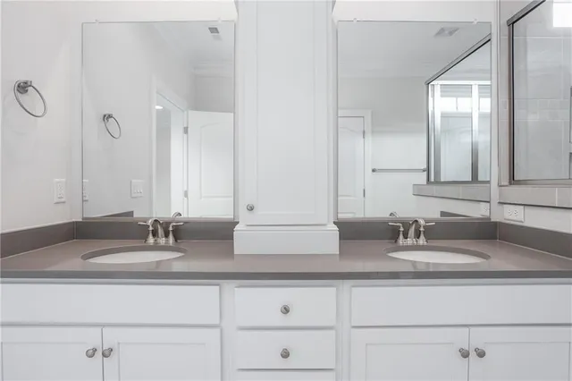 a bathroom with double sink and a mirror