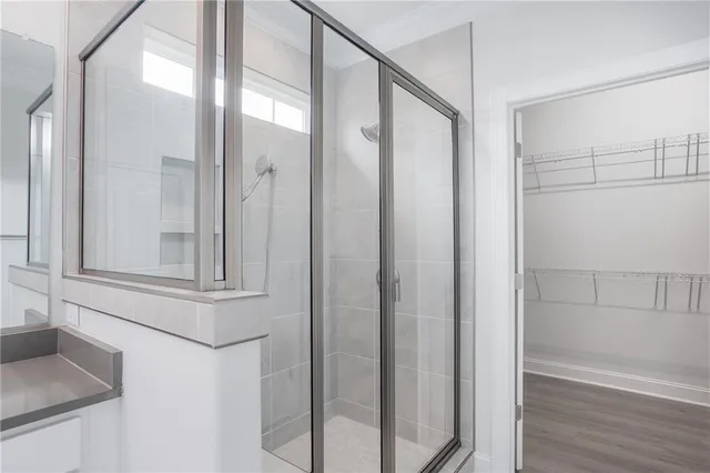 an empty room with wooden floor chandelier fan and windows