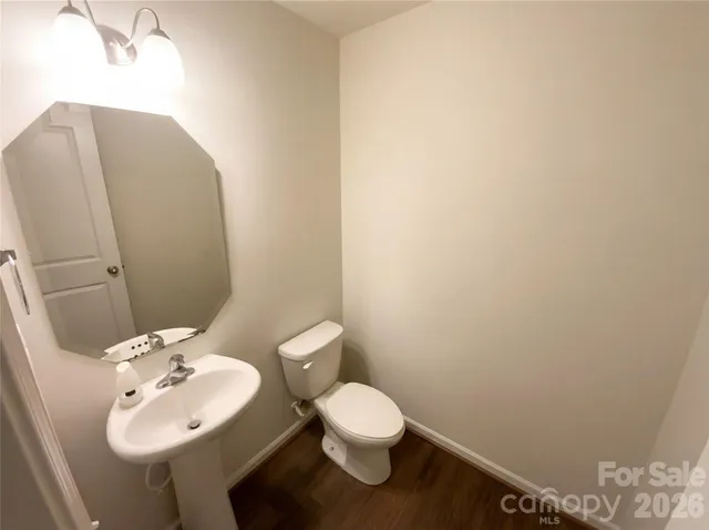 a bathroom with a sink mirror and toilet