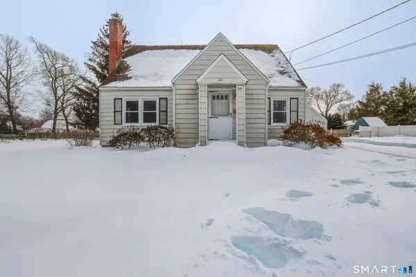 a front view of a house with a yard covered in snow