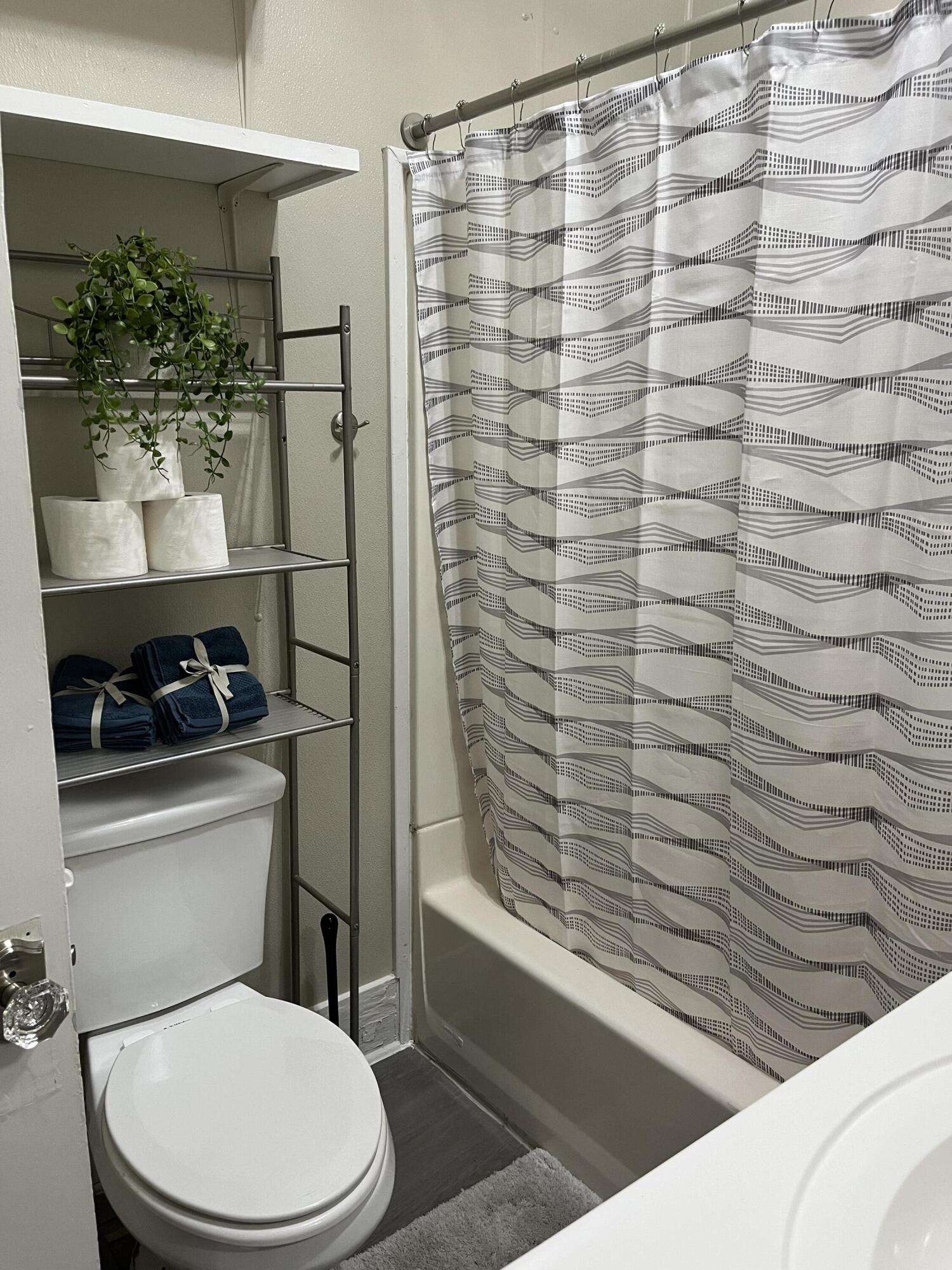 605 South 10th Street Slaton, TX 79364 - Photo 13 of 19 a bathroom with a toilet and a shower curtain