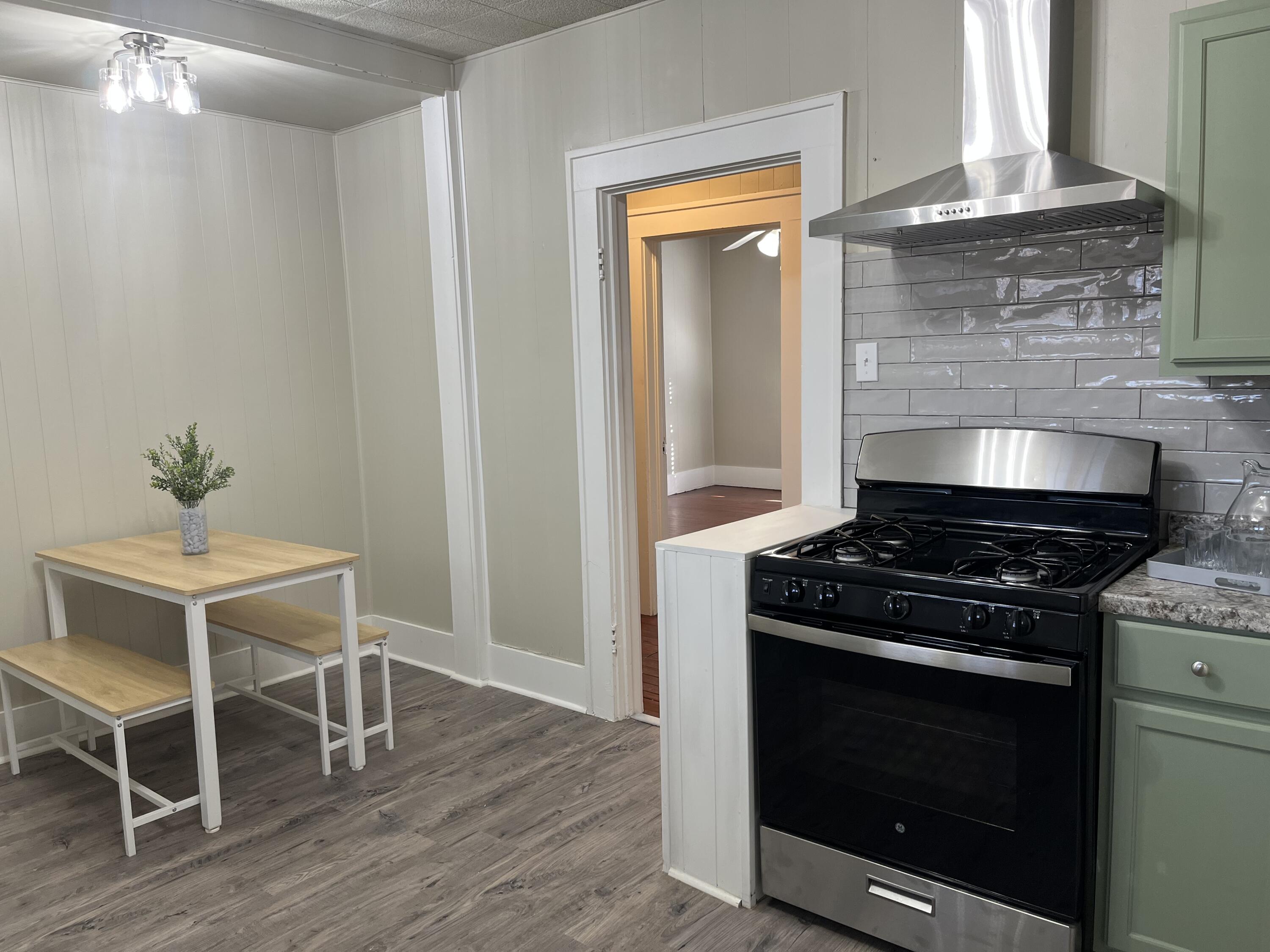 605 South 10th Street Slaton, TX 79364 - Photo 5 of 19 a kitchen with a stove and a wooden floor