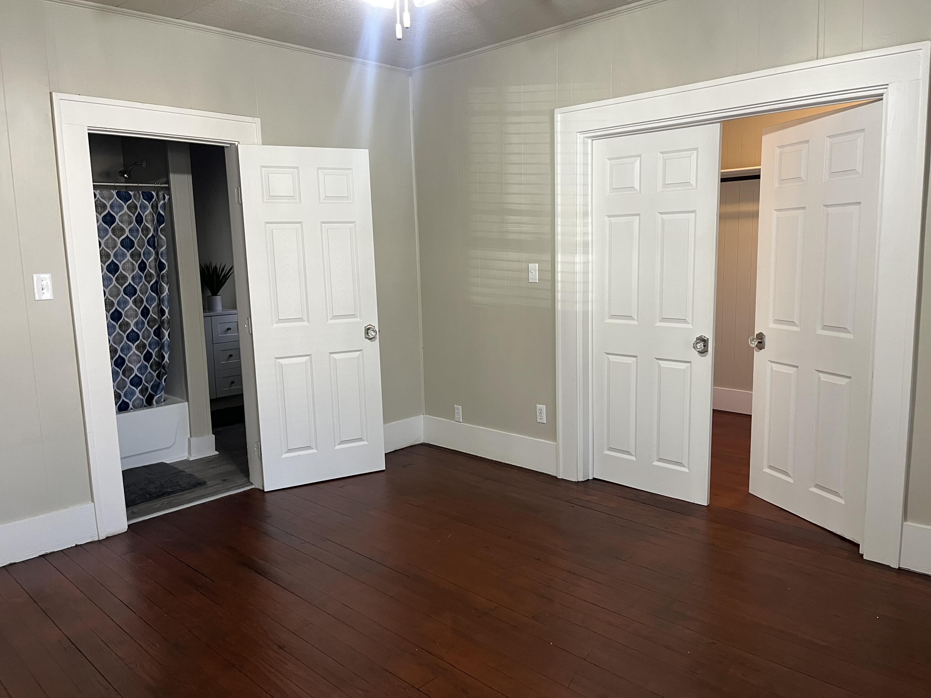 605 South 10th Street Slaton, TX 79364 - Photo 6 of 19 an empty room with wooden floor closet and windows