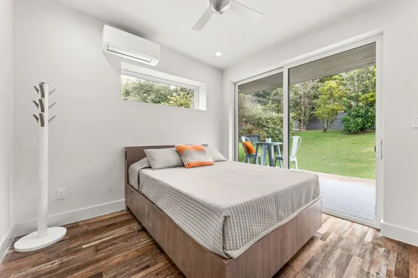 a bed sitting in a spacious bedroom next to a window
