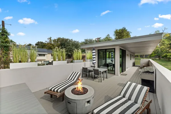 a view of roof deck with table and chairs with wooden fence