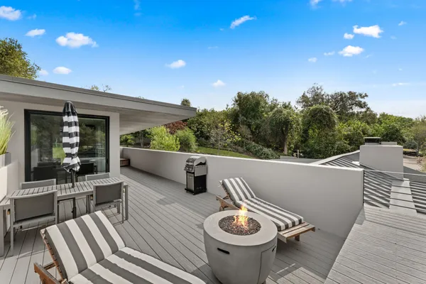 a view of a patio with couches table and chairs and potted plants