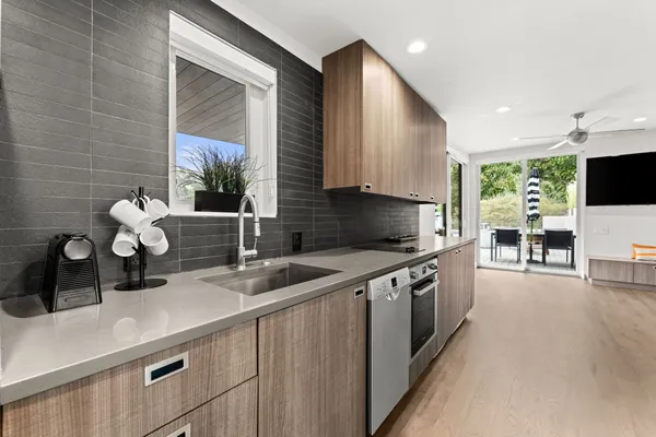 a kitchen with stainless steel appliances a sink a counter top space cabinets and a potted plant