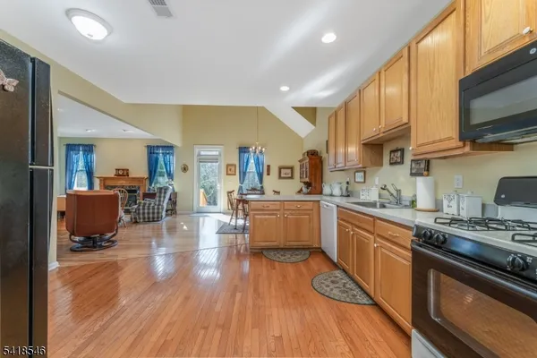a kitchen with stainless steel appliances granite countertop wooden floors stove top oven and sink