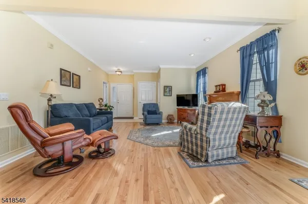 a living room with furniture a wooden floor and next to a window