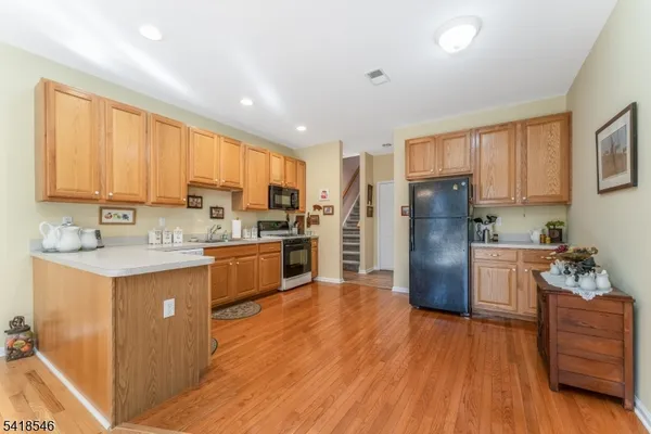 a kitchen with refrigerator cabinets and wooden floor