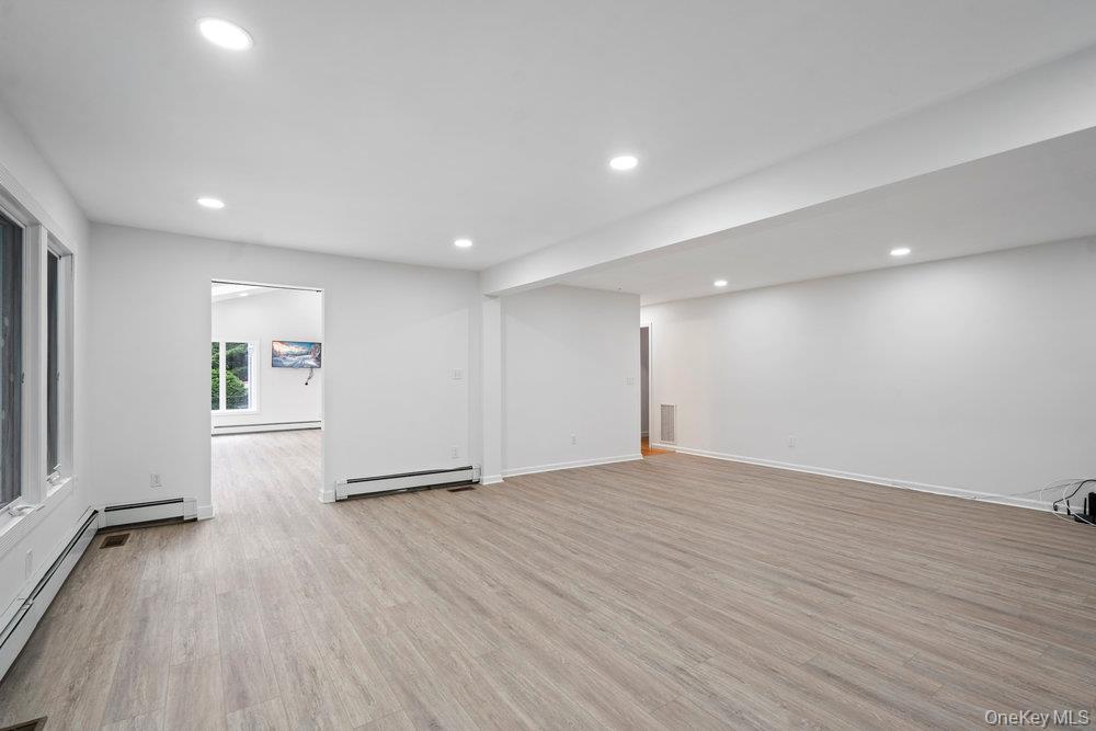 83 Shore Road Mount Sinai, NY 11766 - Photo 11 of 33 an empty room with wooden floor and windows