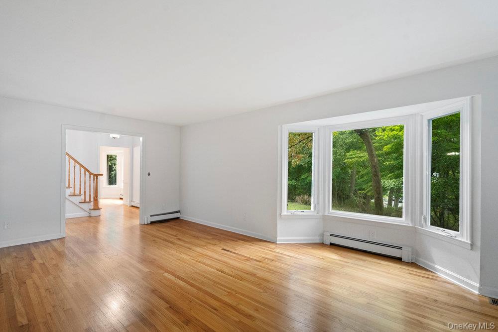 83 Shore Road Mount Sinai, NY 11766 - Photo 13 of 33 a view of an empty room with wooden floor and a window