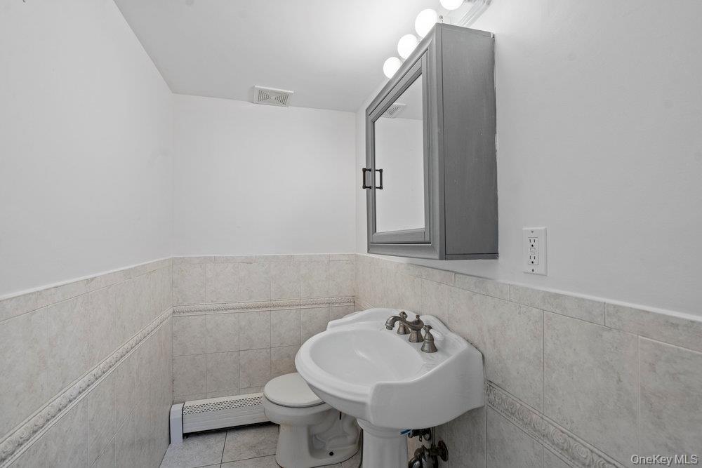 83 Shore Road Mount Sinai, NY 11766 - Photo 16 of 33 a bathroom with a sink mirror and toilet