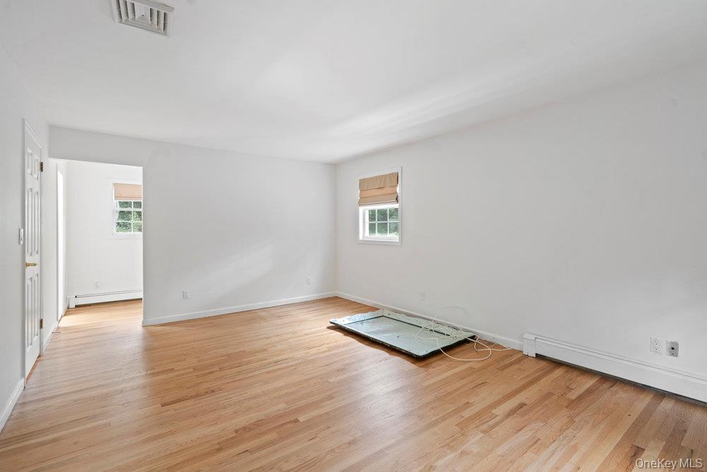 83 Shore Road Mount Sinai, NY 11766 - Photo 20 of 33 an empty room with wooden floor and windows
