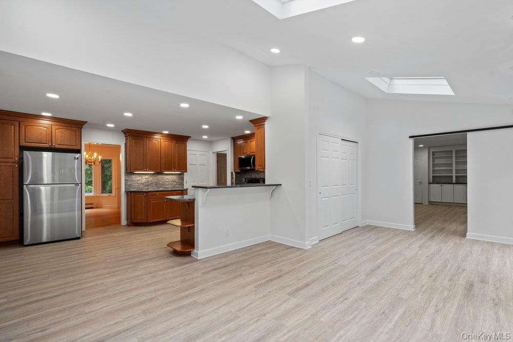83 Shore Road Mount Sinai, NY 11766 - Photo 7 of 33 a view of kitchen with stainless steel appliances kitchen island wooden floors and view living room