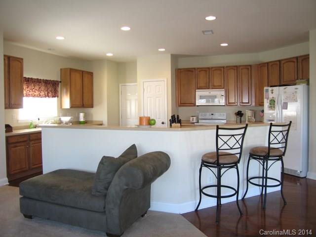 6644 Evanton Loch Road Charlotte, NC 28278 - Photo 10 of 24 a living room with stainless steel appliances kitchen island granite countertop a couch a sink a stove a microwave a dining table and chairs