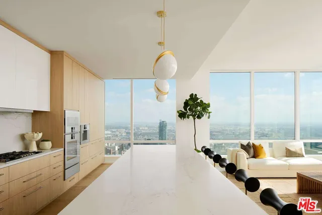 a large white kitchen with a large window and stainless steel appliances