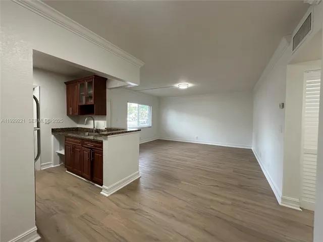 a kitchen with granite countertop a stove and a wooden floors