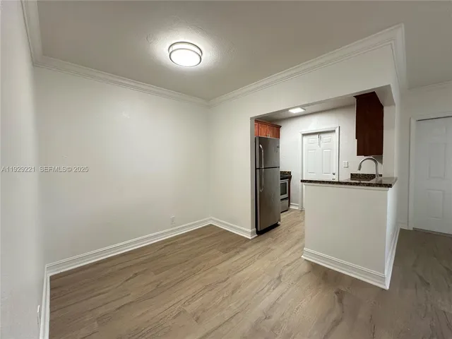 a view of a kitchen with a sink and a refrigerator