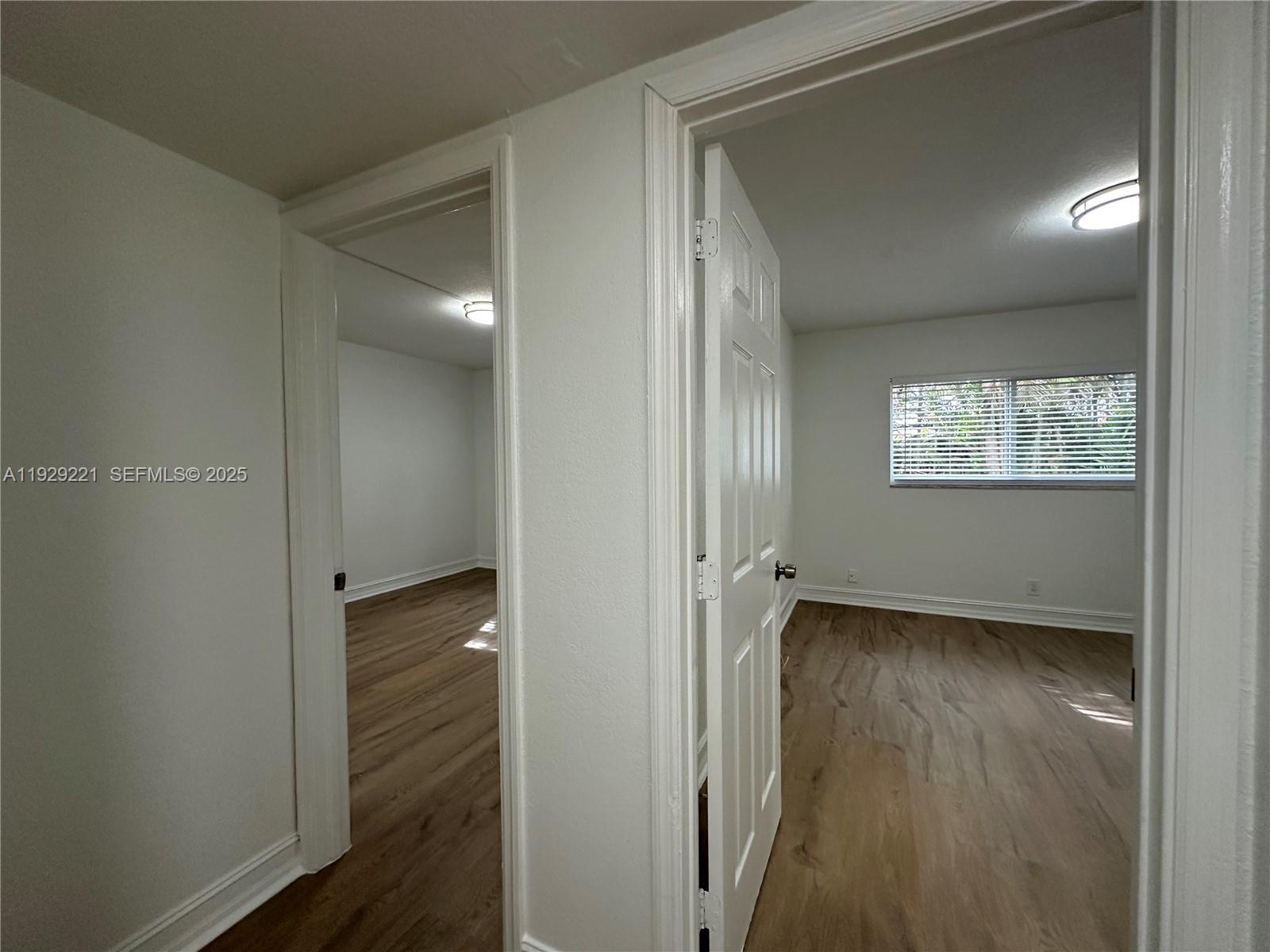 1400 Northeast 56th Street, Unit 105 Fort Lauderdale, FL 33334 - Photo 18 of 42 a view of an empty room with wooden floor and a closet