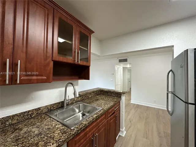 a kitchen with granite countertop stainless steel appliances a sink and cabinets