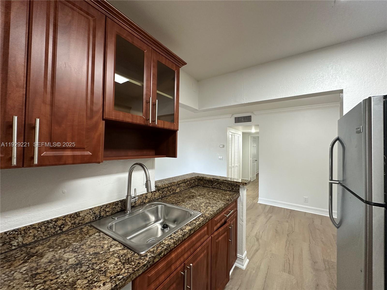 1400 Northeast 56th Street, Unit 105 Fort Lauderdale, FL 33334 - Photo 10 of 42 a kitchen with granite countertop stainless steel appliances a sink and cabinets