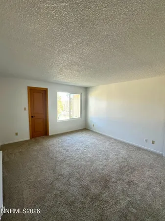 an empty room with a window and closet