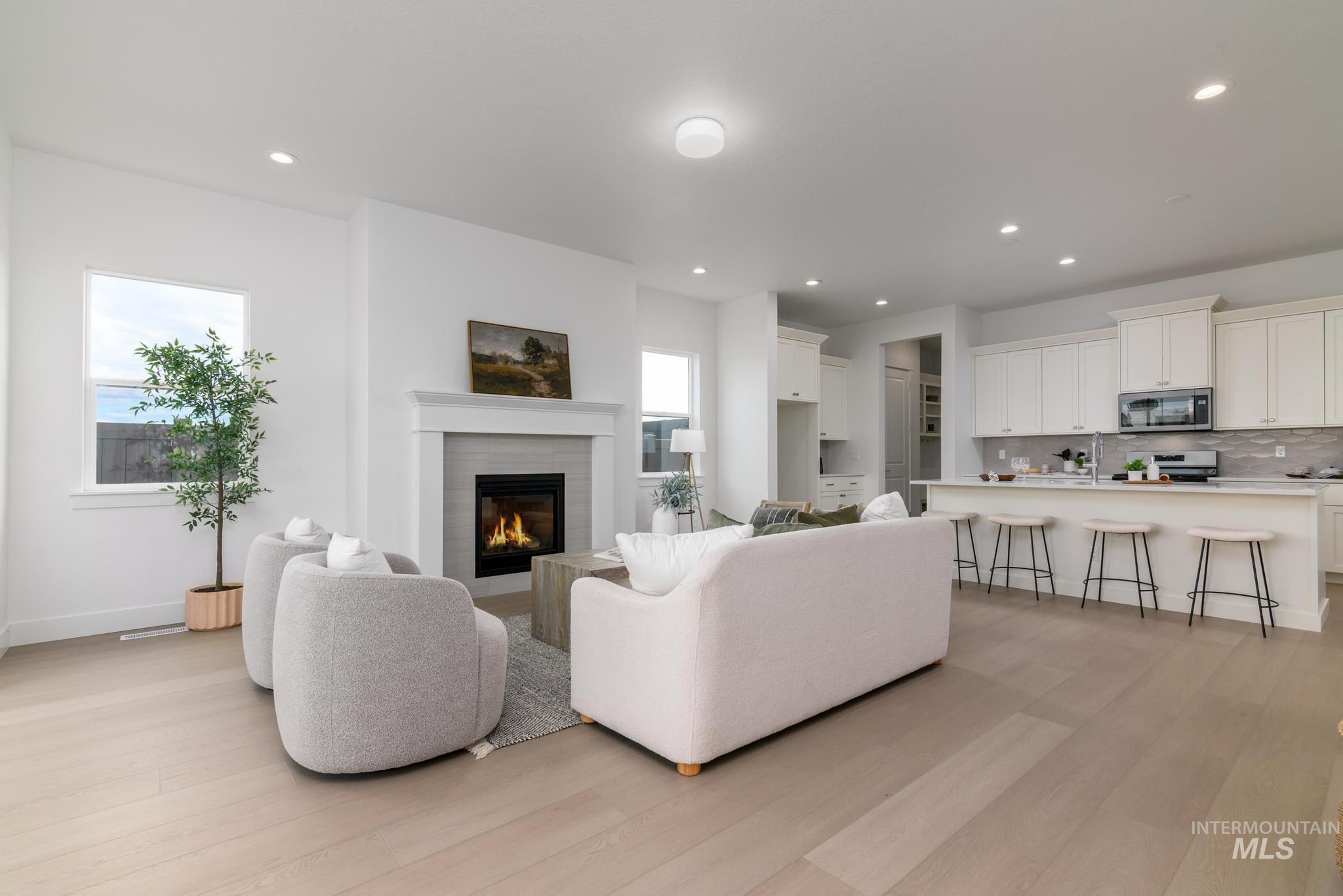 8555 West Fanning Street Star, ID 83669 - Photo 3 of 11 Living room with light wood finished floors, a glass covered fireplace, and recessed lighting