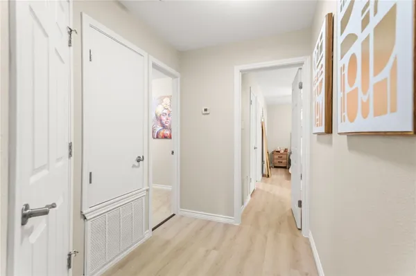 a view of a hallway with wooden floor and closet area