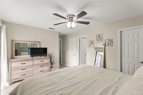 a bedroom with a bed and a flat tv screen on the dresser
