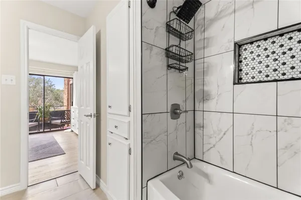 a bathroom with a tub a mirror and shower