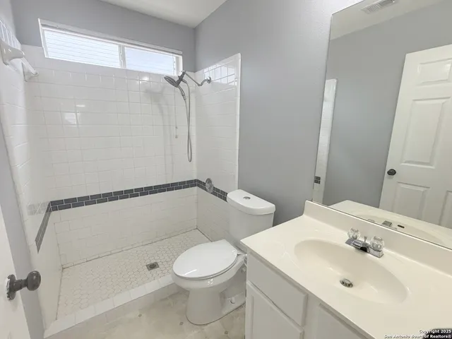 a bathroom with a toilet a sink and shower