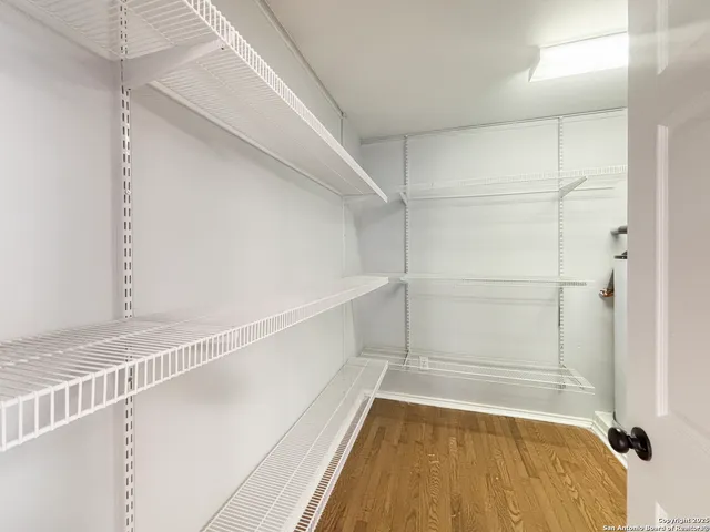a view of walk in closet with empty racks