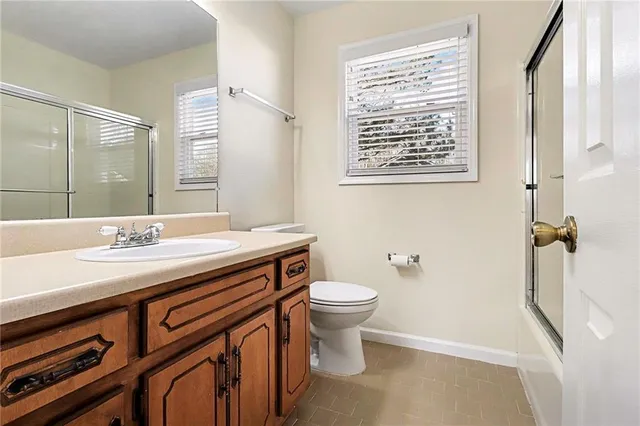 a bathroom with a sink a toilet a mirror and shower