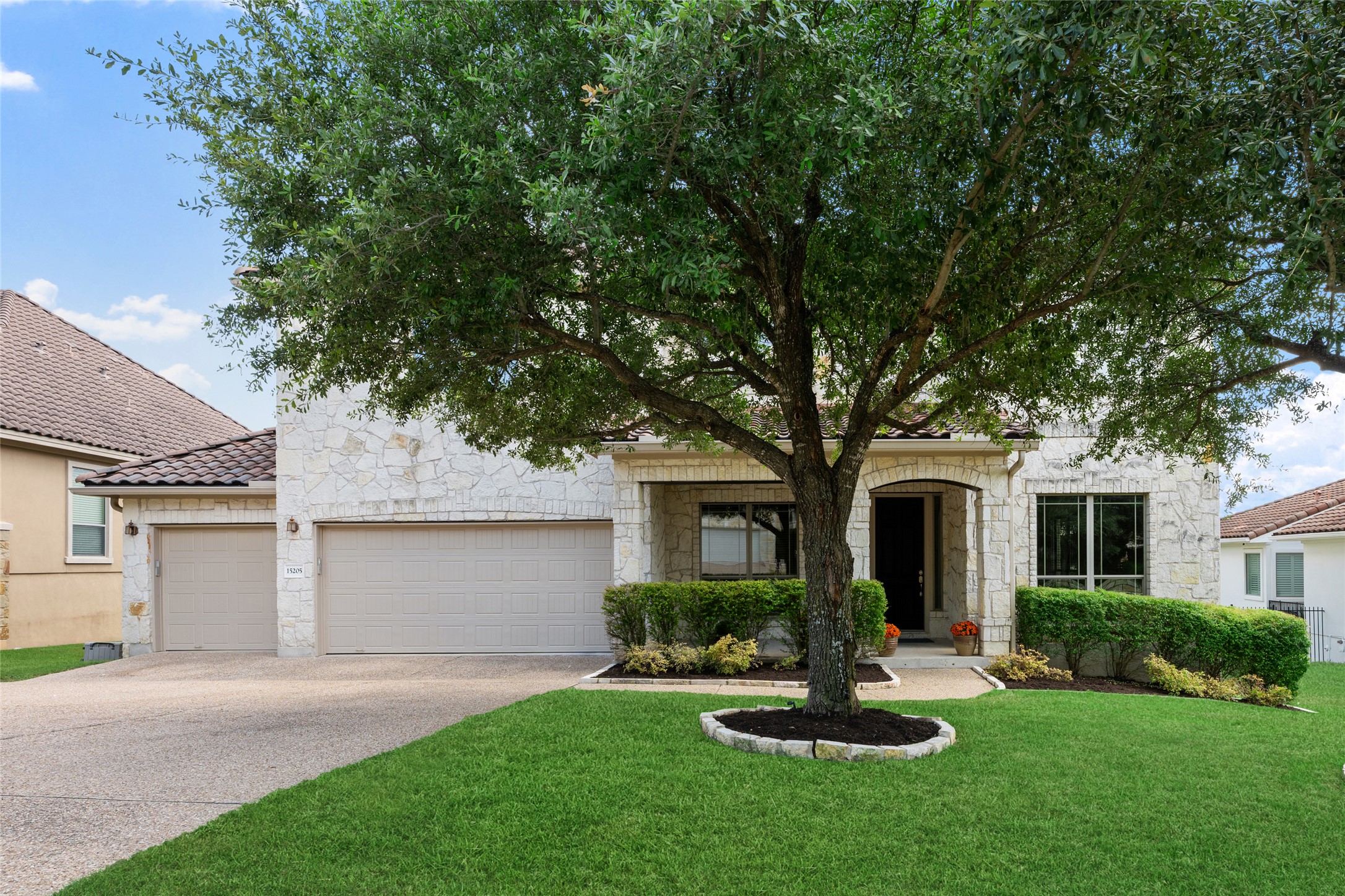 15205 Spillman Ranch Loop Austin, TX 78738 - Photo 1 of 40 A well-maintained lawn and mature tree enhance the curb appeal of this charming stone-clad home with an inviting arched entry.