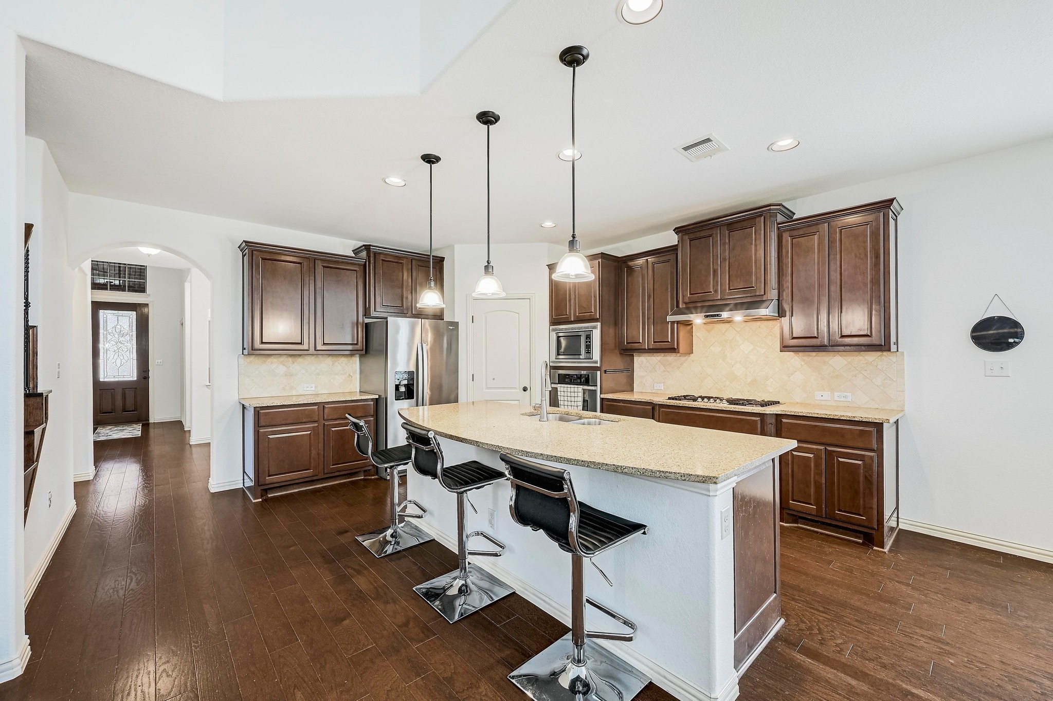 2229 Turtle Mountain Bend Austin, TX 78748 - Photo 2 of 38 a kitchen with stainless steel appliances a stove a sink a kitchen island with chairs and wooden floor