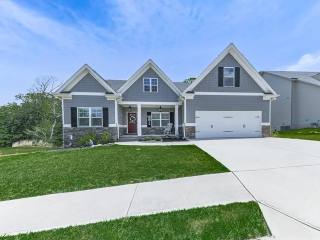a front view of a house with a yard and trees