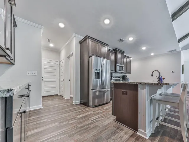 a kitchen with stainless steel appliances granite countertop a refrigerator and a sink