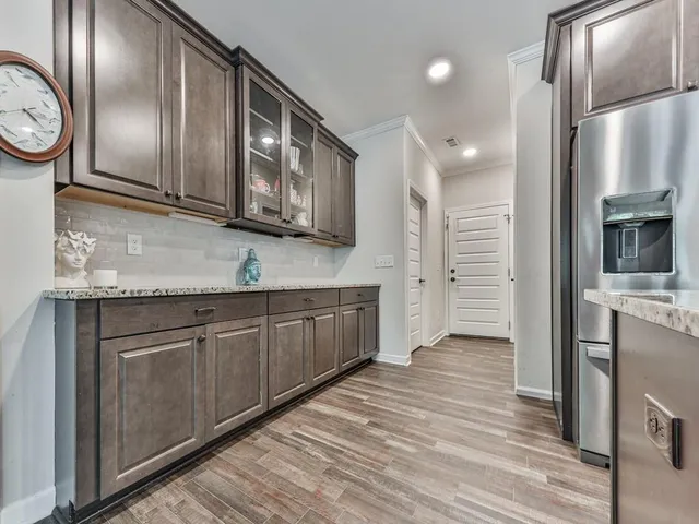 a kitchen with stainless steel appliances granite countertop a refrigerator a stove and a sink with granite countertops