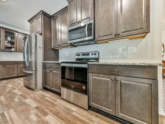 a kitchen with granite countertop stainless steel appliances and wooden cabinets