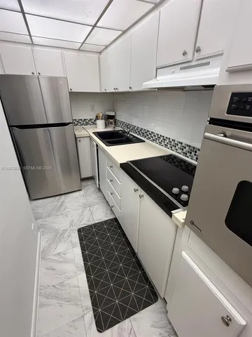 a kitchen with granite countertop a sink stove and cabinets