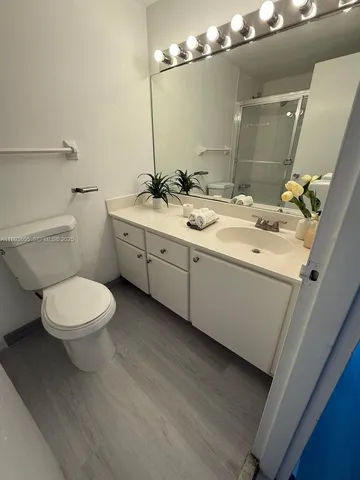a bathroom with a toilet a sink and mirror