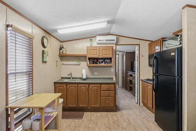 a kitchen with stainless steel appliances granite countertop a refrigerator and a sink