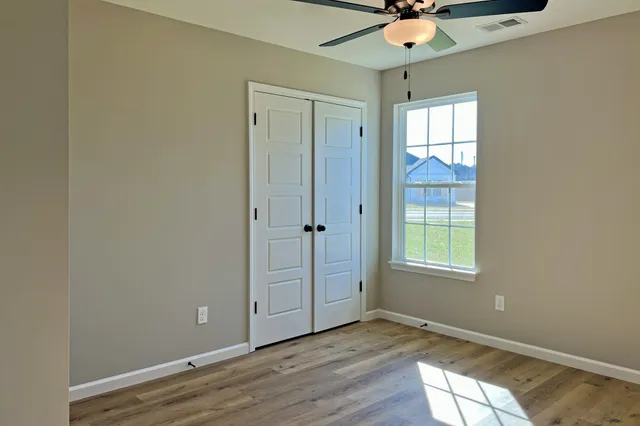 an empty room with fan and windows