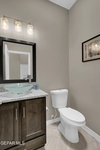 a bathroom with a granite countertop toilet a mirror and a sink