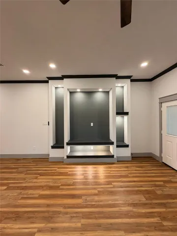 a view of a room with kitchen island stainless steel appliances wooden floor and window