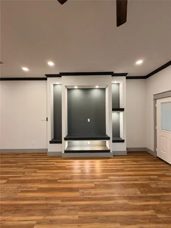 a view of an empty room with kitchen and a window