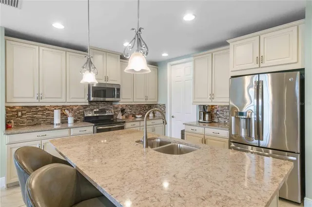 a kitchen with stainless steel appliances granite countertop a sink refrigerator and cabinets