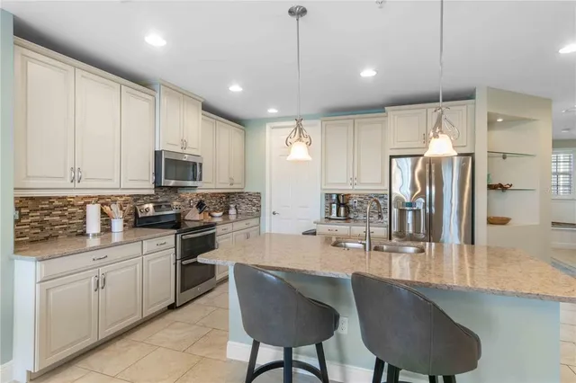 a kitchen with kitchen island granite countertop a sink window and white cabinets