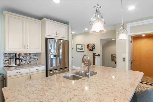 a kitchen with kitchen island a sink a counter and chairs